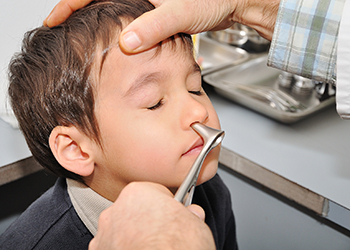 Doctor hand checking a boy`s nose