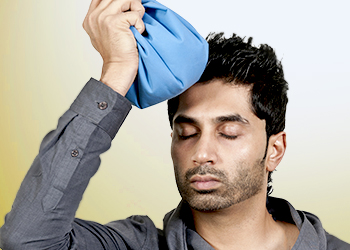 A man applying ice bag to his head