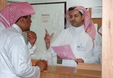 medical records staff member assisting a visitor at the medical records office